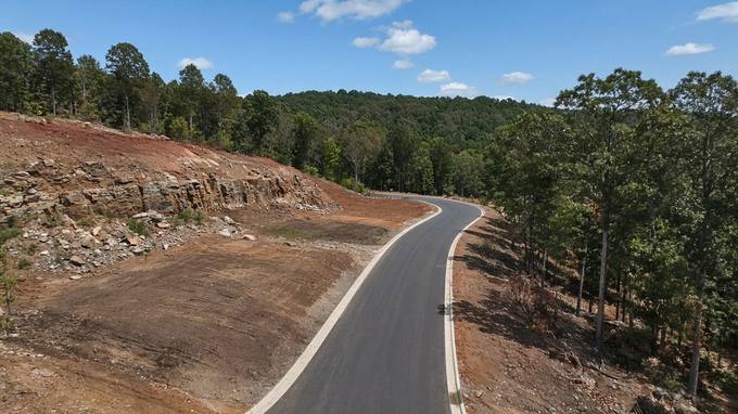 Finished Paved Emerald Drive Curving Past Native Stone Bluff Cut